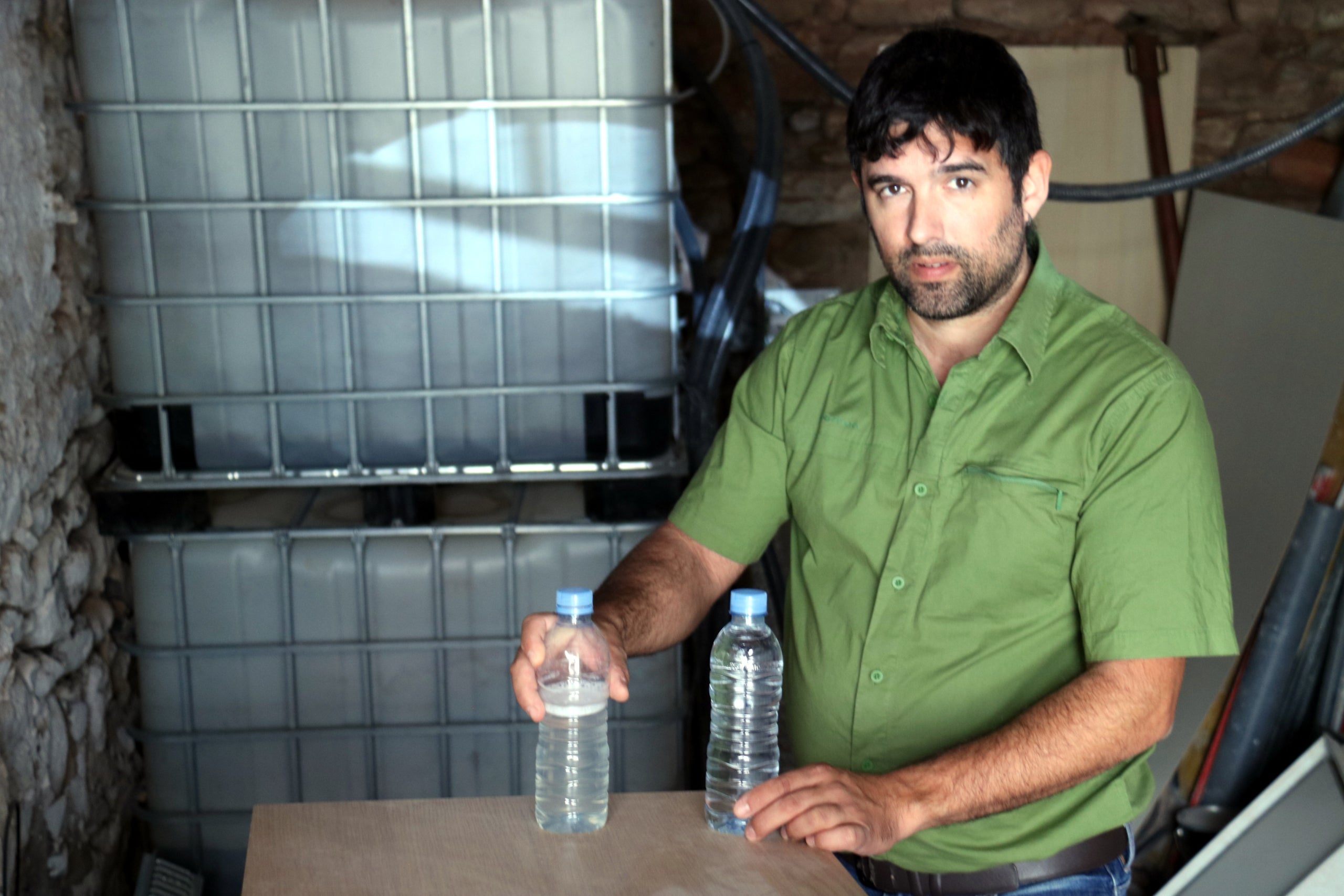 Jordi Arnau amb dues mostres d'aigua: una de reaprofitada i una altra d'embotellada / ACN