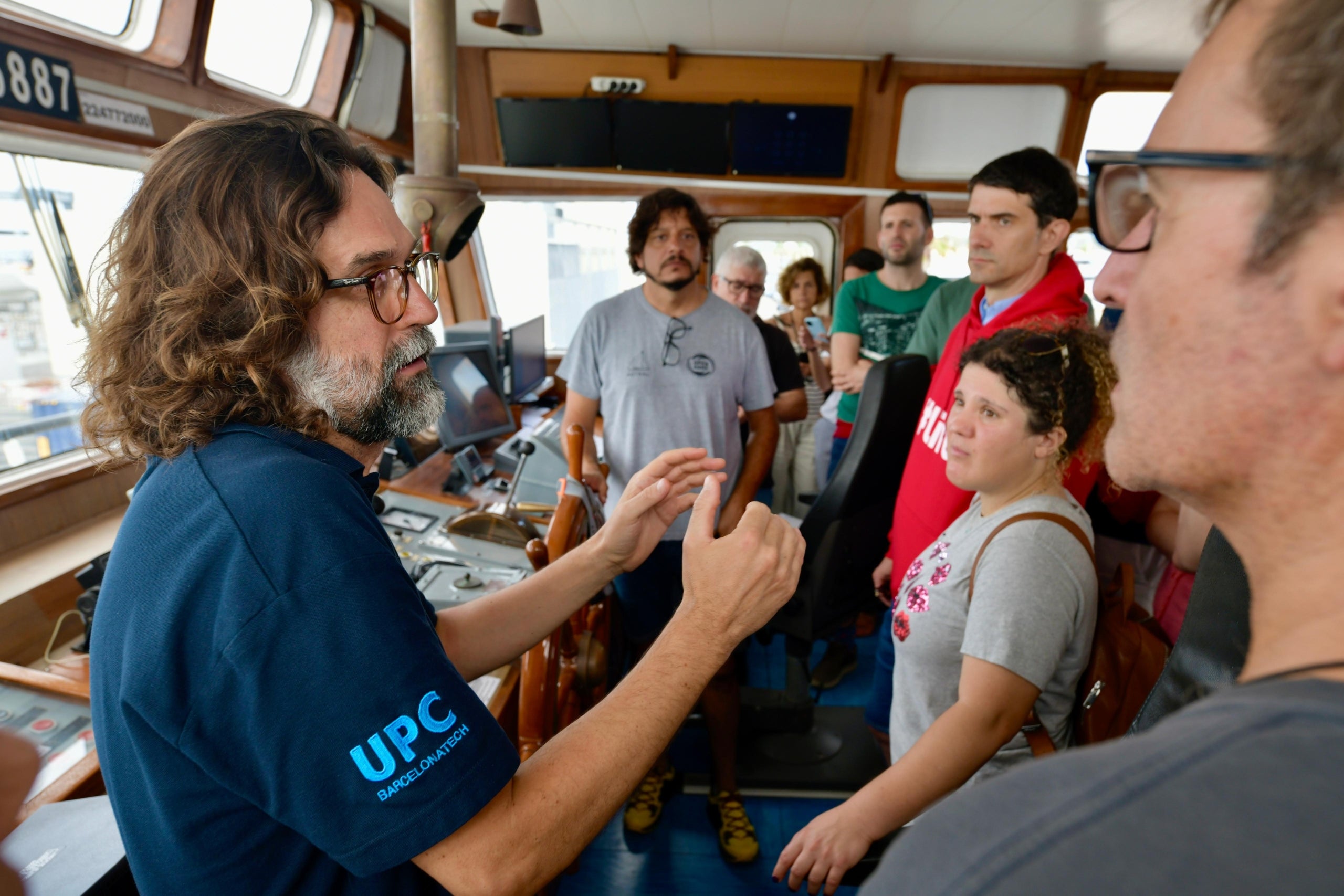 Xavier Martínez, profesor de la FNB, con representantes de Open Arms y Fractus, al cuadro de mando del barco de Open Arms | UPC