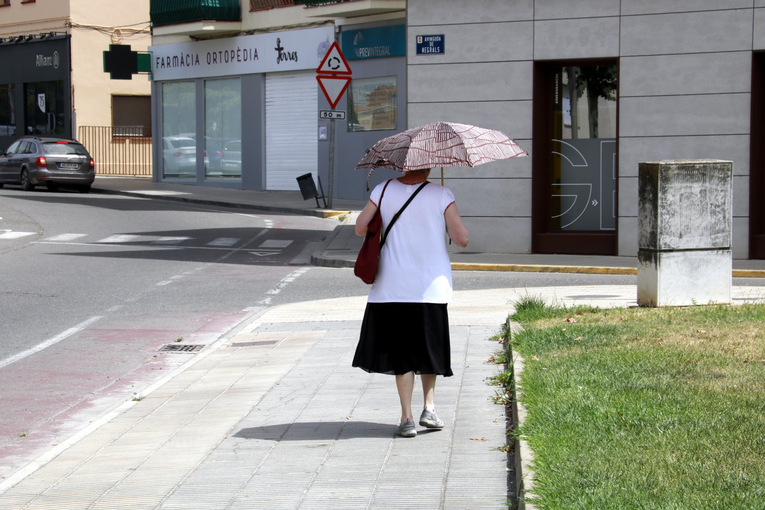 Una persona passeja per Mollerussa amb un paraigua per protegir-se del sol | Anna Berga (ACN)