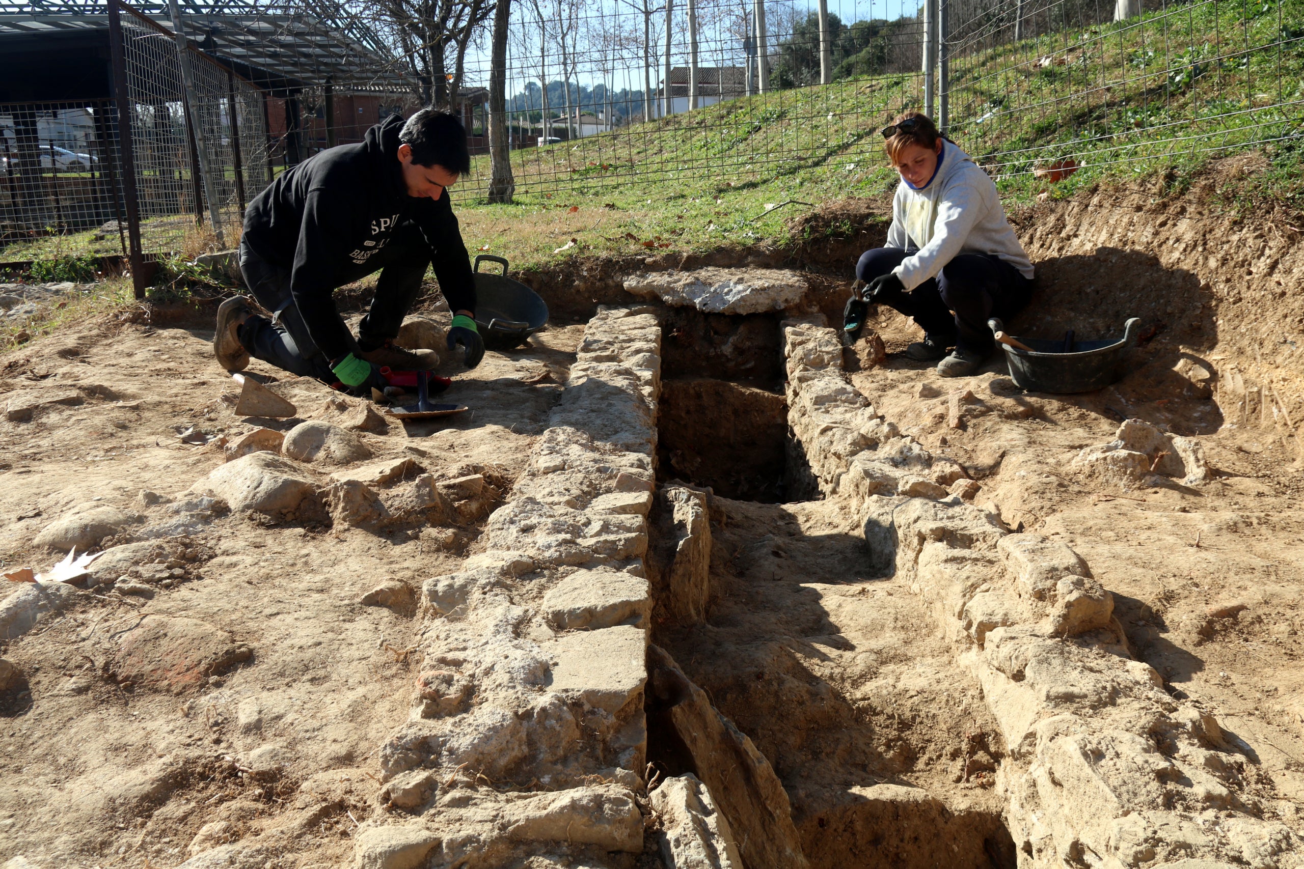 Dos arqueòlegs de la UdG excavant el tram d'aqüeducte del segle I que s'ha descobert a la vil·la romana del Pla de l'Horta | Xavier Pi (ACN)