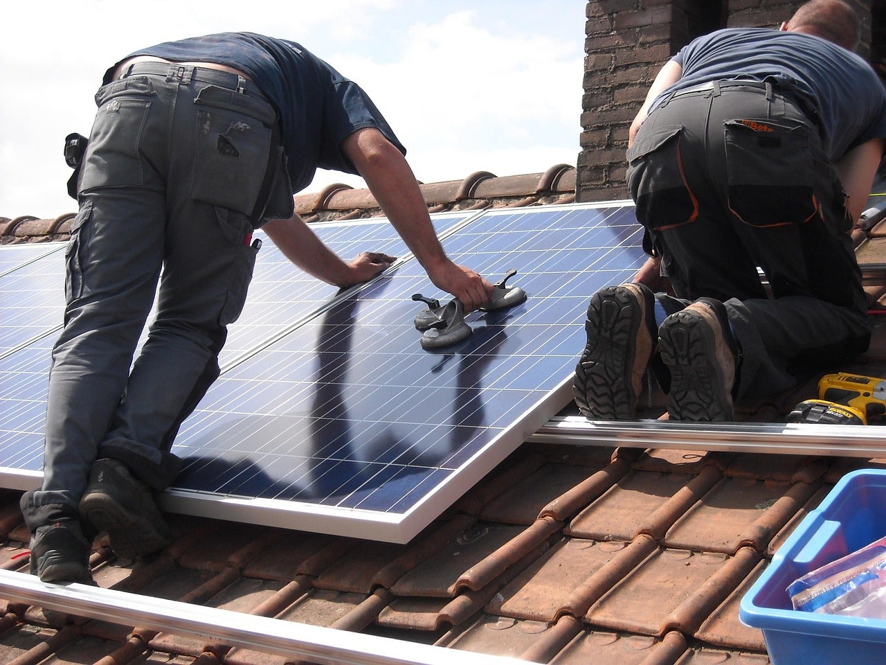 Operaris instal·lant plaques solars per generar energia fotovoltaica / Pixabay