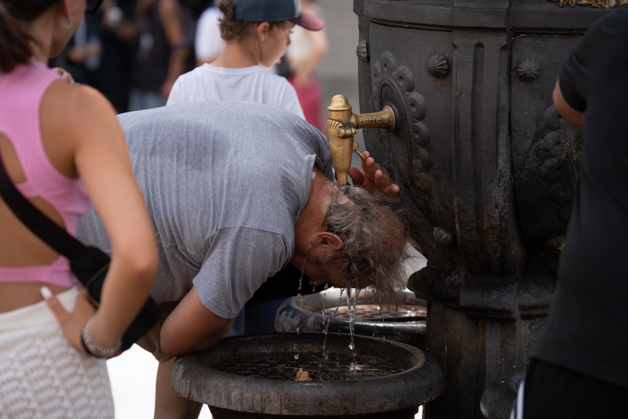 Imatge d'arxiu d'una persona refrescant-se a la font de Canaletes el 18 de juliol de 2023 a Barcelona | David Zorrakino / Europa Press