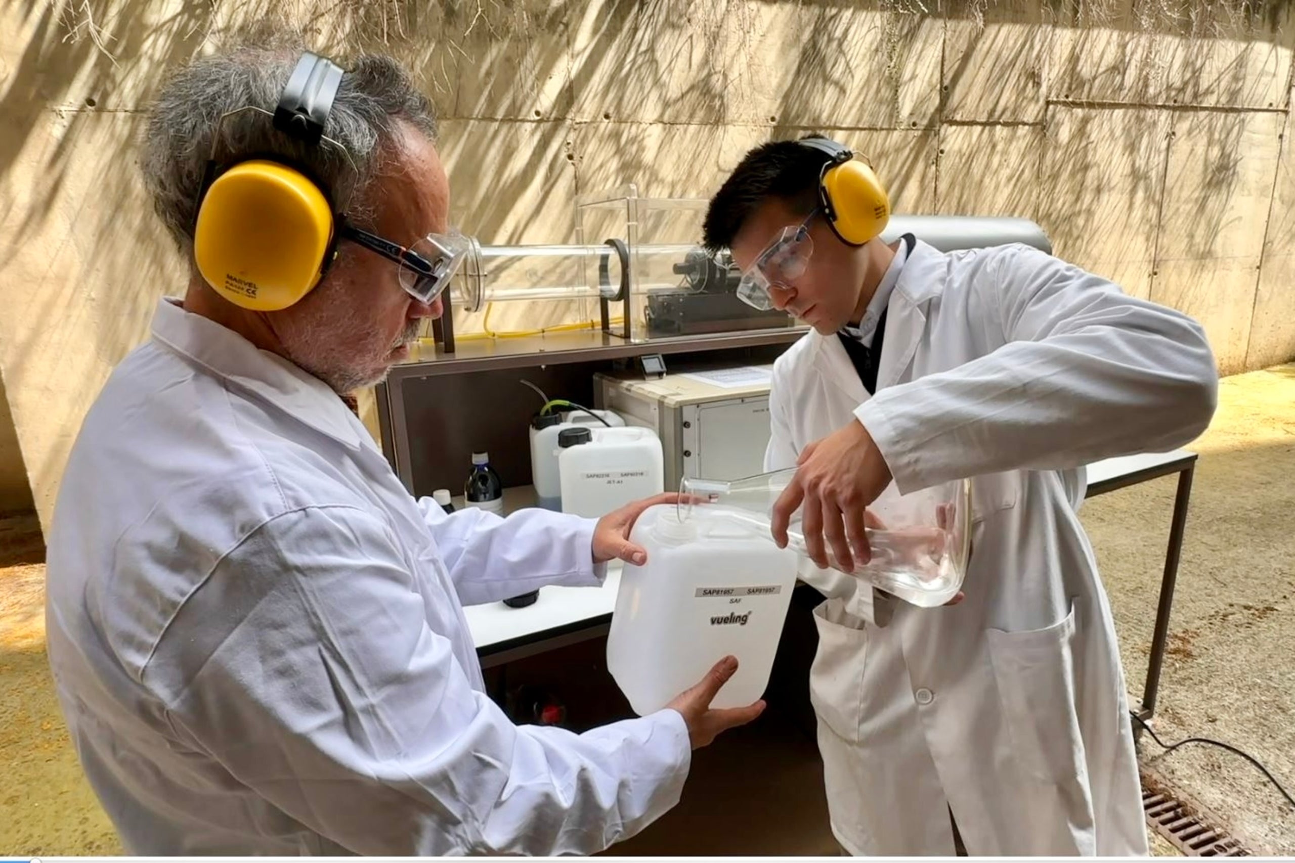 Manel Sòria, investigador del grupo de investigación de la UPC, y un miembro de su equipo, manipulan el SAF para realizar pruebas con el turborreactor en la ESEIAAT. | Cedida a la ACN por la UPC