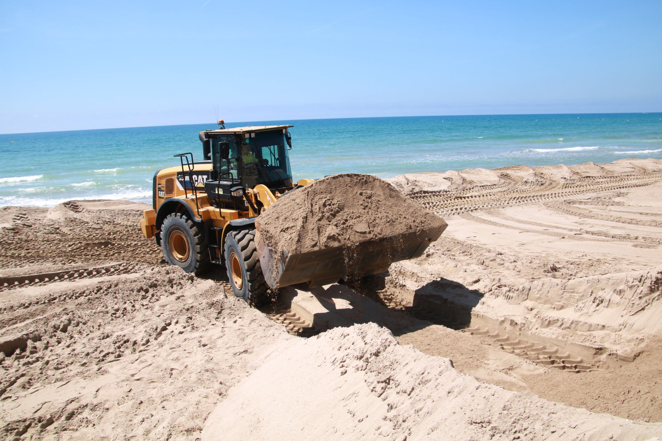 Una de les màquines movent sorra a la platja de Calafell | Mar Rovira (ACN)