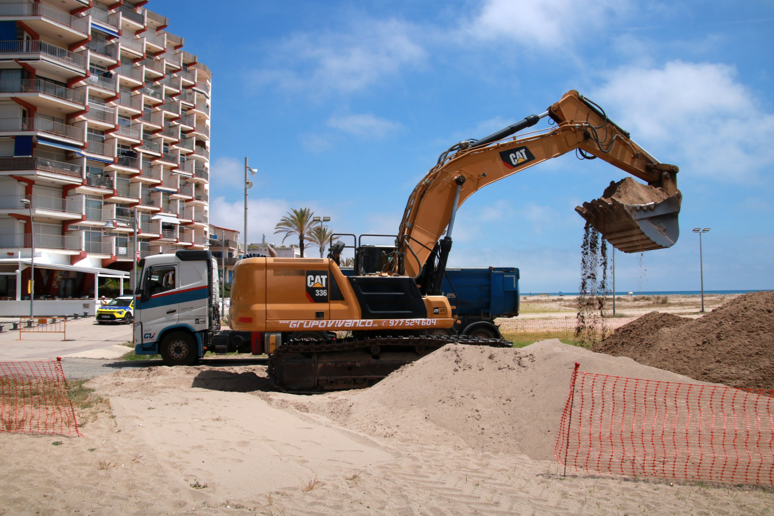 Una de les màquines omplint un dels camions per traspassar sorra del port de Coma-ruga cap a la platja de Calafell | Mar Rovira (ACN)