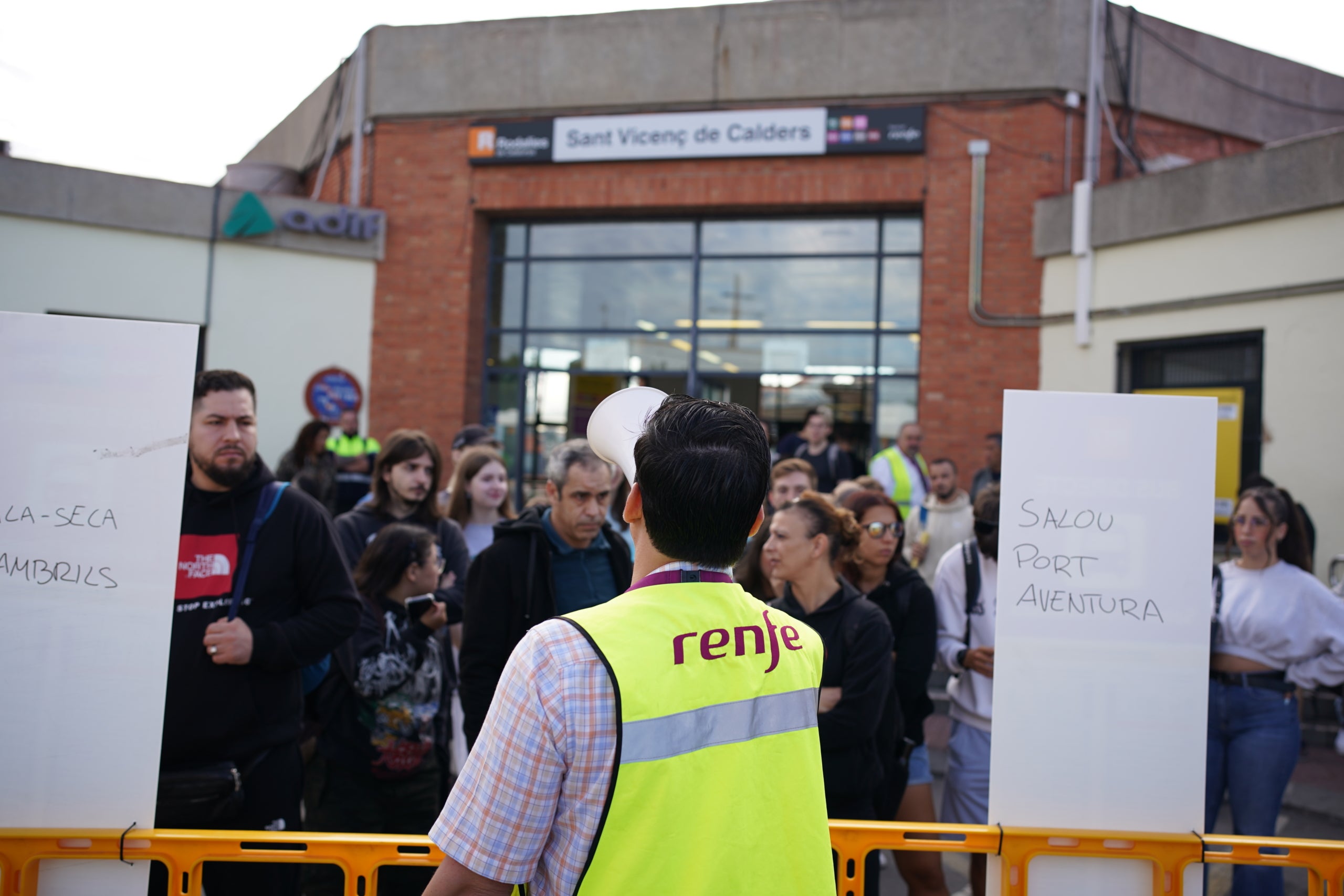 Un informador de Renfe donant indicacions a usuaris amb un megàfon a l'estació de Sant Vicenç de Calders | Joan Mateu Parra (ACN)