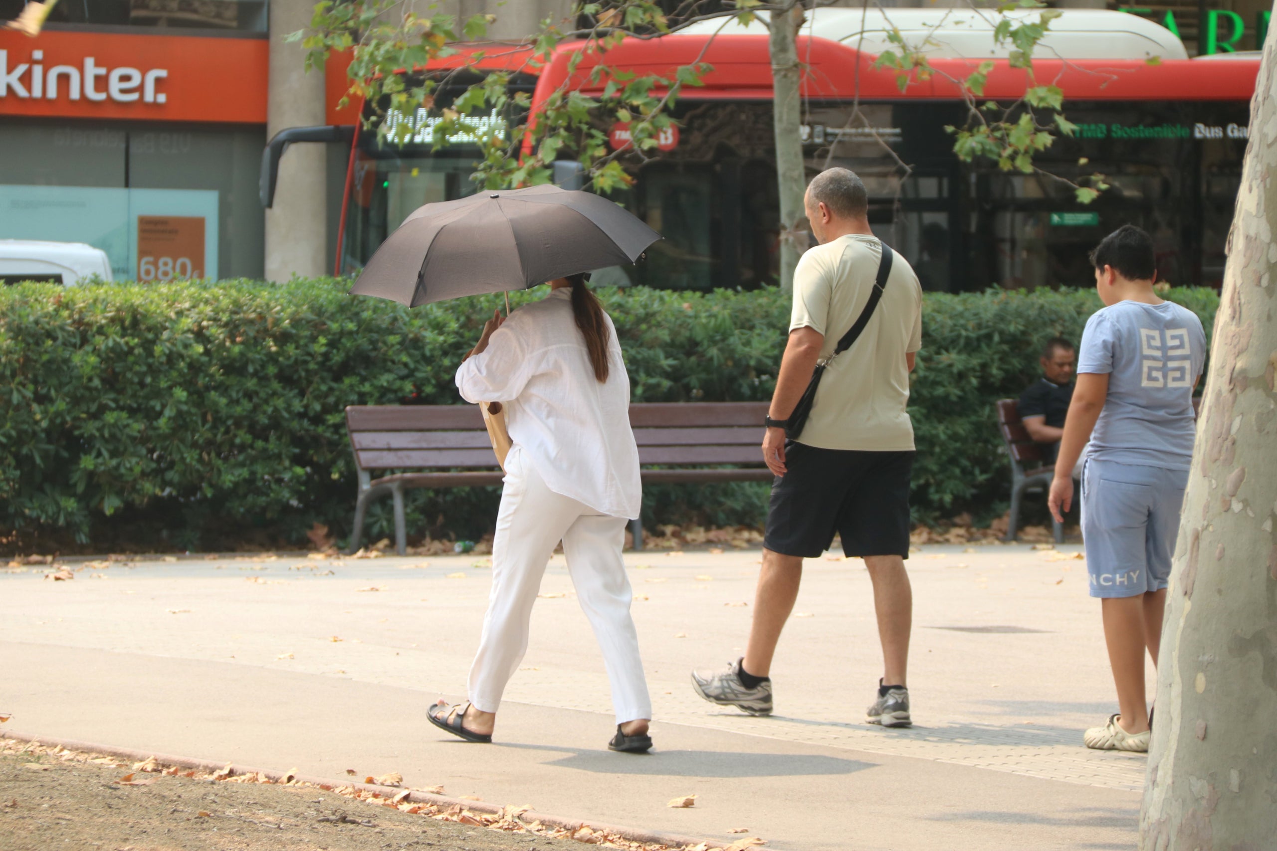 Una dona es protegeix del sol amb un paraigues durant el pic de l'onada de calor a Barcelona | Maria Asmarat (ACN)