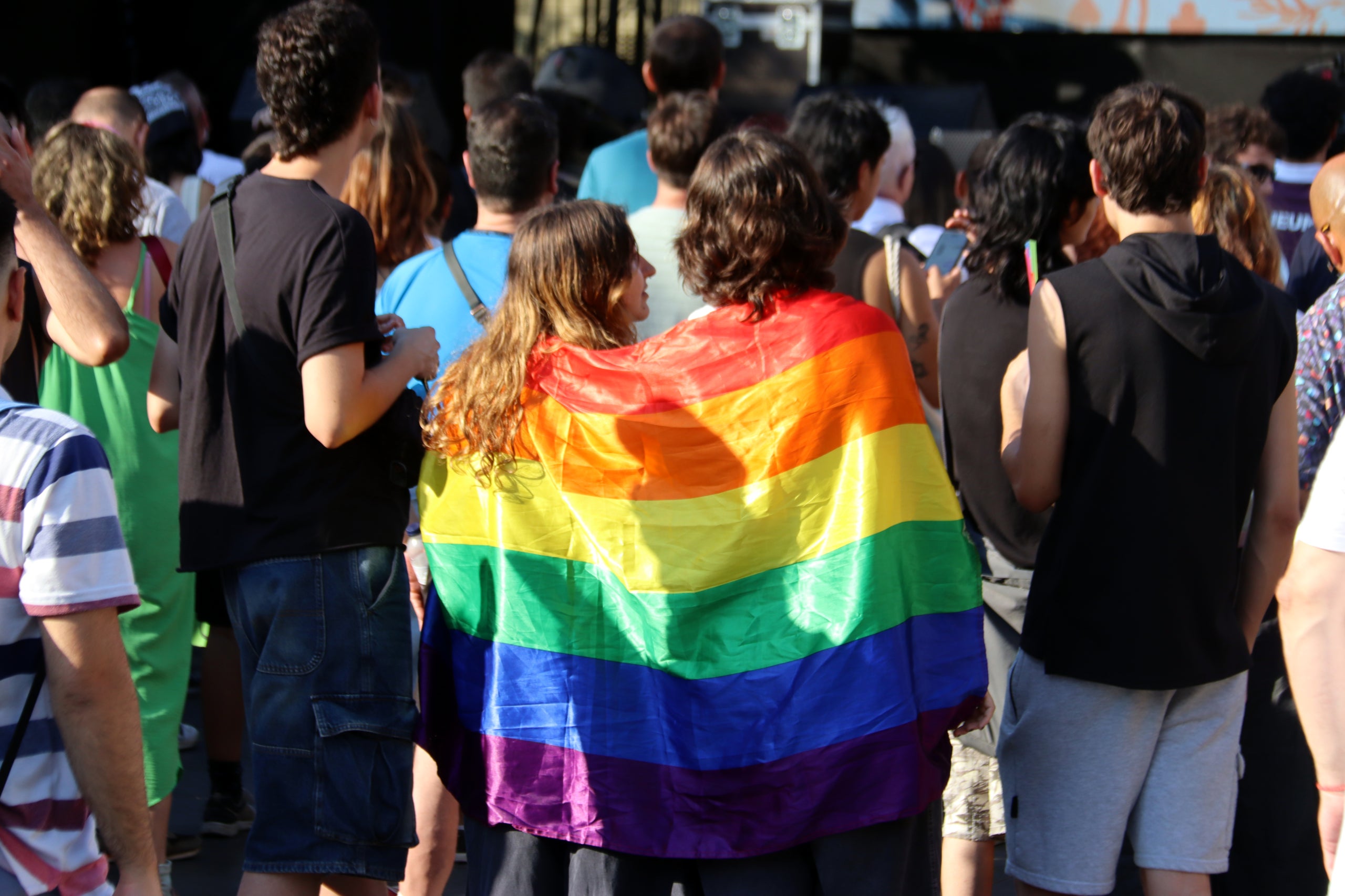 Dues noies amb una bandera LGTBI en el pregó del Pride Barcelona. | Nazaret Romero (ACN)